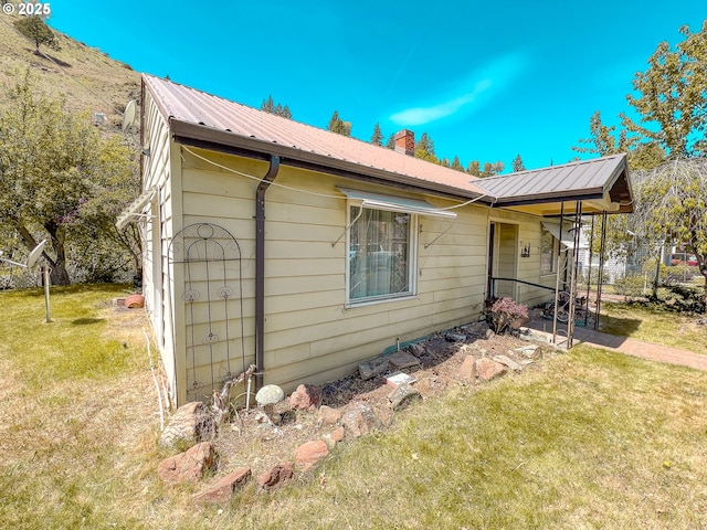 413 SW Brent Dr, John Day, OR 97845 - view of side of home featuring a yard, metal roof, and a chimney