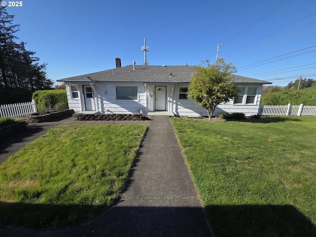 view of front of property featuring a chimney, a front lawn, and fence