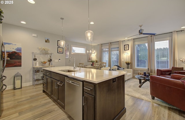 kitchen featuring sink, dark brown cabinets, dishwasher, an island with sink, and pendant lighting