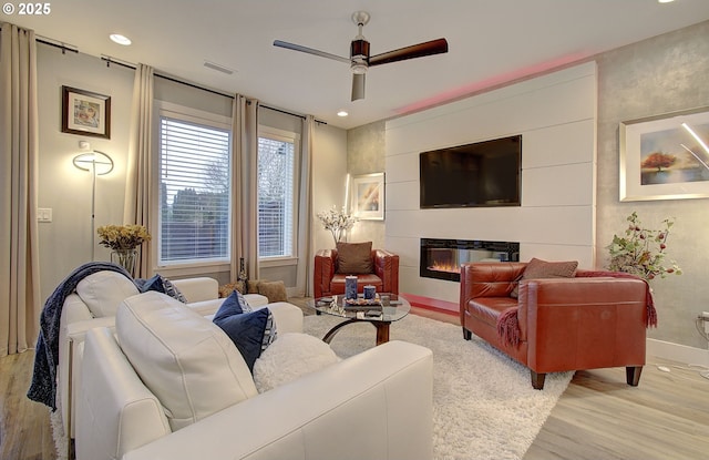 living room with ceiling fan and light hardwood / wood-style flooring