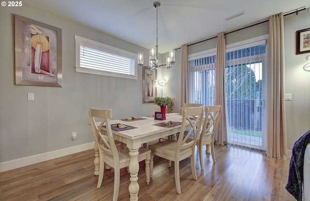 dining space with an inviting chandelier and light wood-type flooring