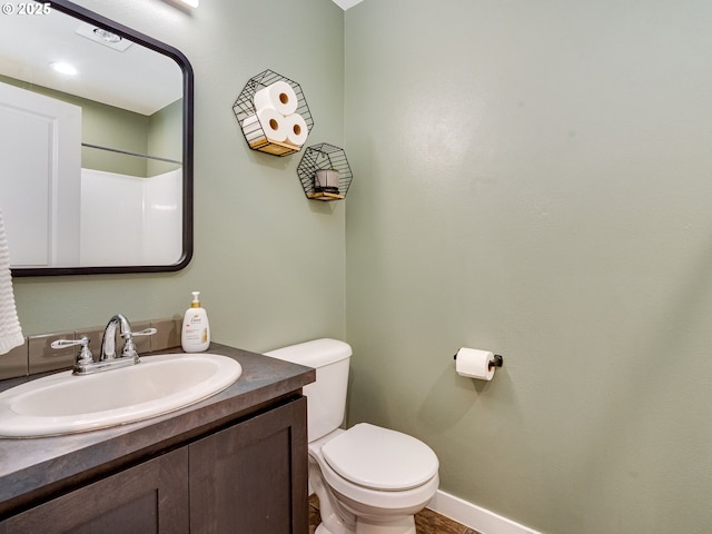 bathroom with vanity, toilet, and baseboards