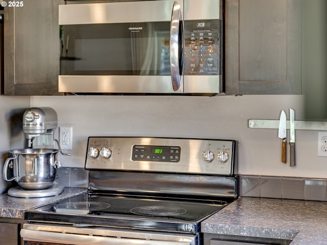 room details featuring dark brown cabinets, appliances with stainless steel finishes, and dark countertops