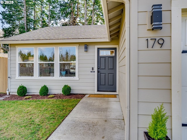 doorway to property featuring roof with shingles