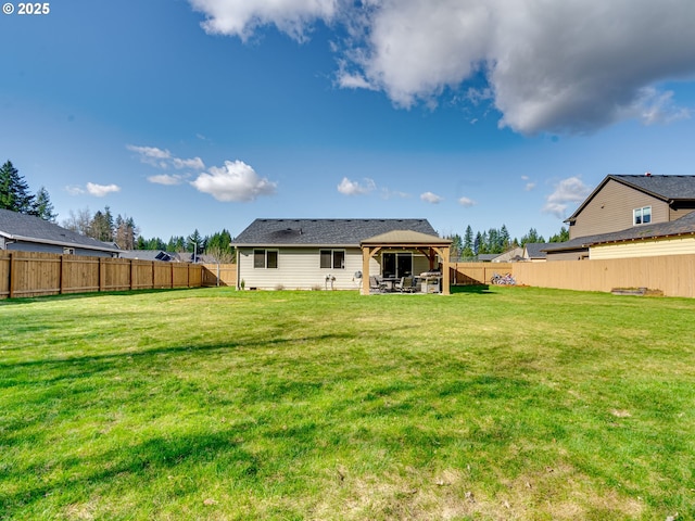 rear view of property featuring a fenced backyard, a lawn, a patio, and a gazebo