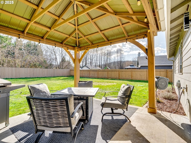 view of patio with outdoor dining area, a fenced backyard, and a gazebo