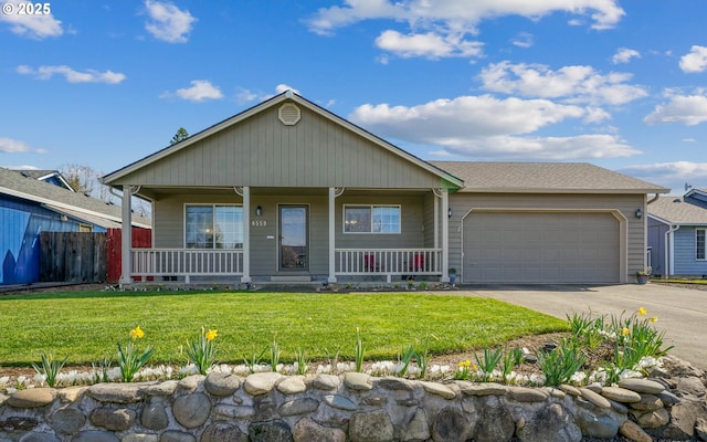 view of front of property with a garage, driveway, covered porch, and a front lawn