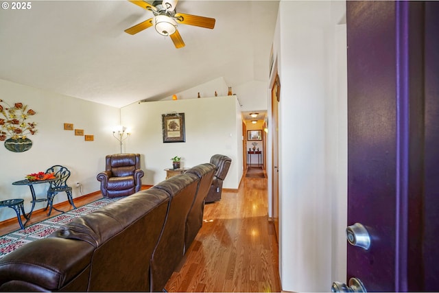 living room with a ceiling fan, lofted ceiling, wood finished floors, and baseboards