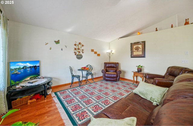 living area featuring baseboards, lofted ceiling, and wood finished floors