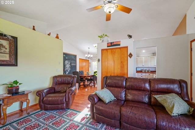 living room featuring ceiling fan with notable chandelier, lofted ceiling, and wood finished floors