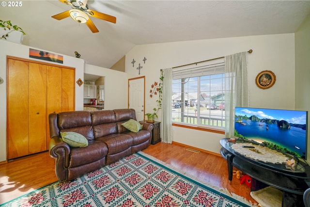 living room with visible vents, wood finished floors, a ceiling fan, and vaulted ceiling