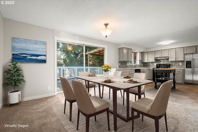 dining space with a textured ceiling, a wealth of natural light, and baseboards