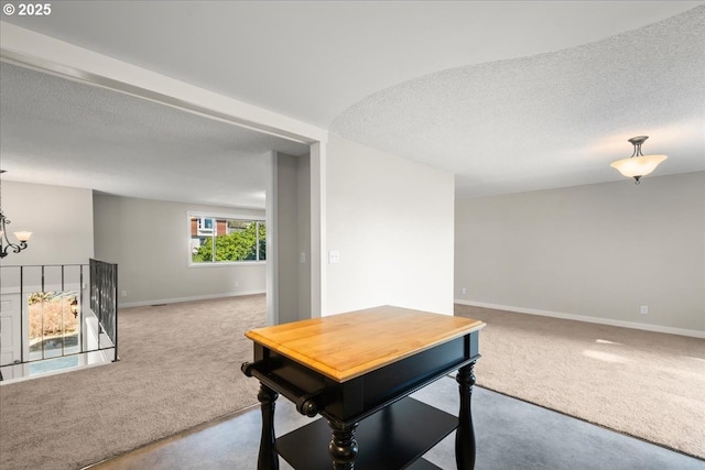 carpeted office space featuring a textured ceiling, baseboards, and an inviting chandelier