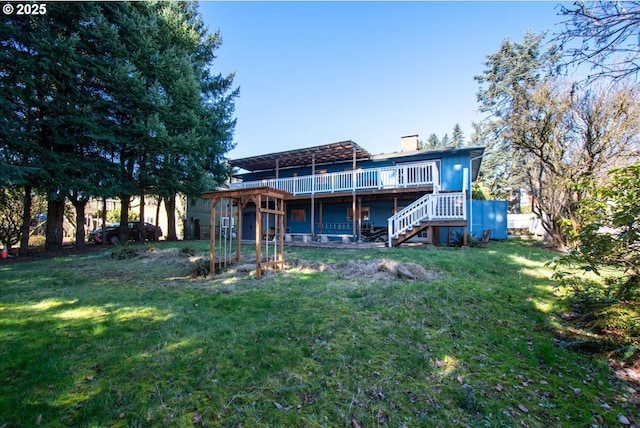 back of property with stairway, a chimney, a wooden deck, and a lawn