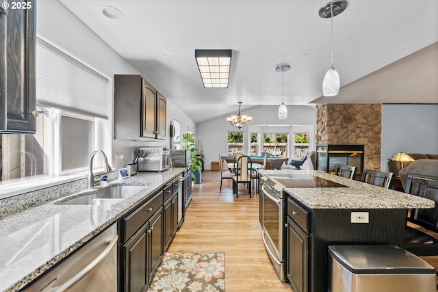 307 Cambridge Dr, Sutherlin, OR 97479 - kitchen with a sink, stainless steel appliances, open floor plan, light wood finished floors, and vaulted ceiling