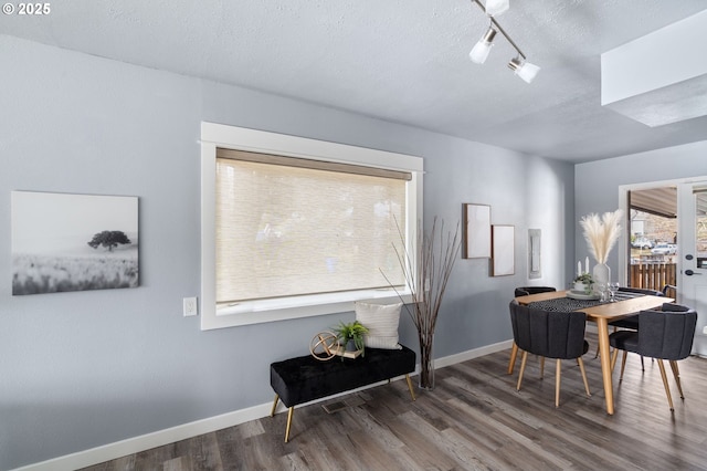 dining space featuring dark hardwood / wood-style flooring and a textured ceiling