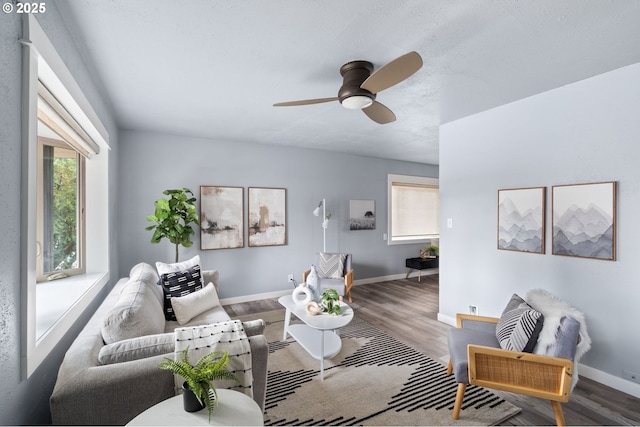 living room featuring ceiling fan, plenty of natural light, and wood-type flooring