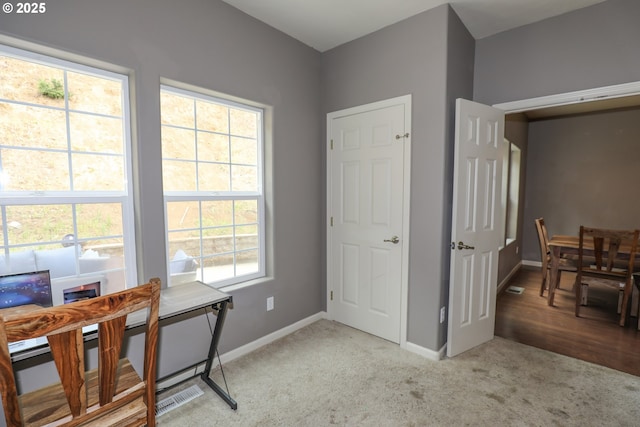 office space with baseboards and light colored carpet