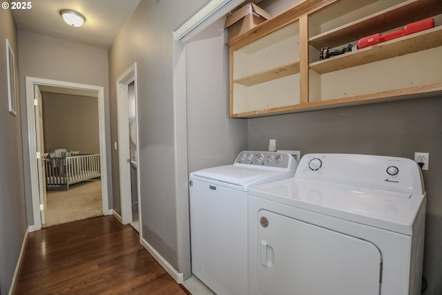 clothes washing area with independent washer and dryer, dark wood-type flooring, and baseboards