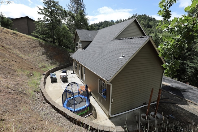 356 Wild Fern Dr, Winchester, OR 97495 - view of side of home with a trampoline, a patio area, roof with shingles, and cooling unit