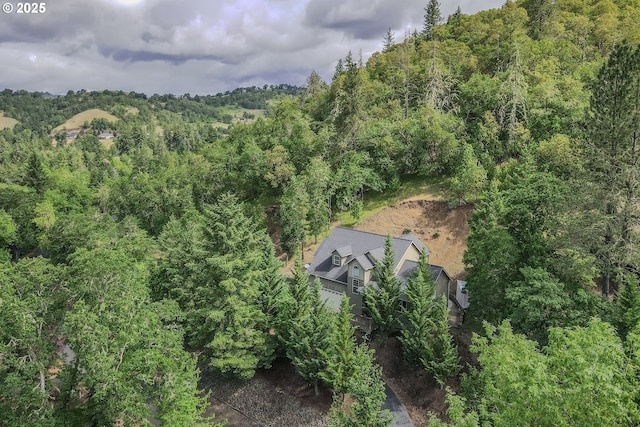 view of subject property with a heavily wooded area