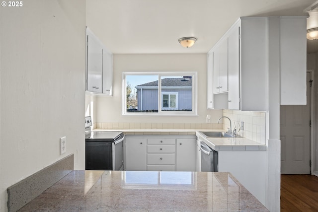 kitchen featuring stainless steel appliances, white cabinetry, tasteful backsplash, and sink