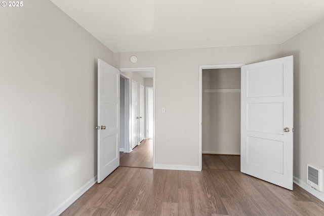 unfurnished bedroom with hardwood / wood-style flooring and a closet