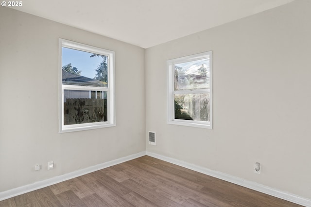 spare room with a healthy amount of sunlight and hardwood / wood-style flooring