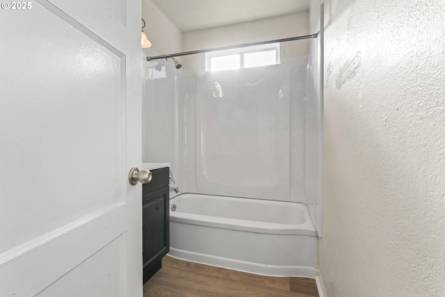 bathroom with wood-type flooring and washtub / shower combination