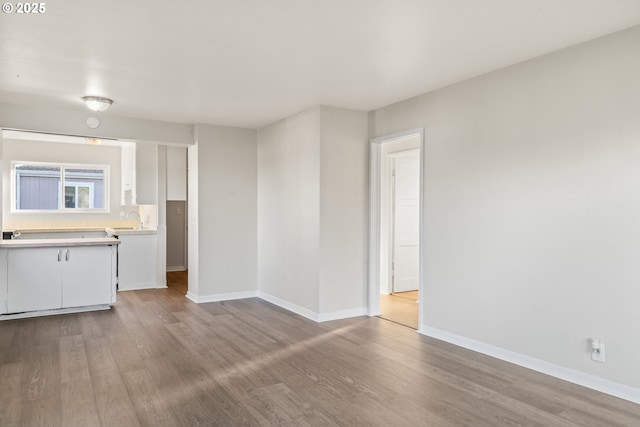 unfurnished living room with light hardwood / wood-style flooring and sink