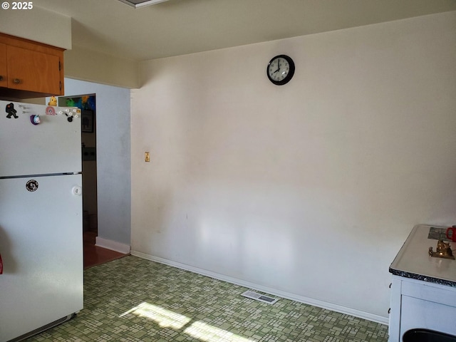 2640 Court Ave, Baker City, OR 97814 - kitchen with freestanding refrigerator, tile patterned floors, baseboards, and dark countertops
