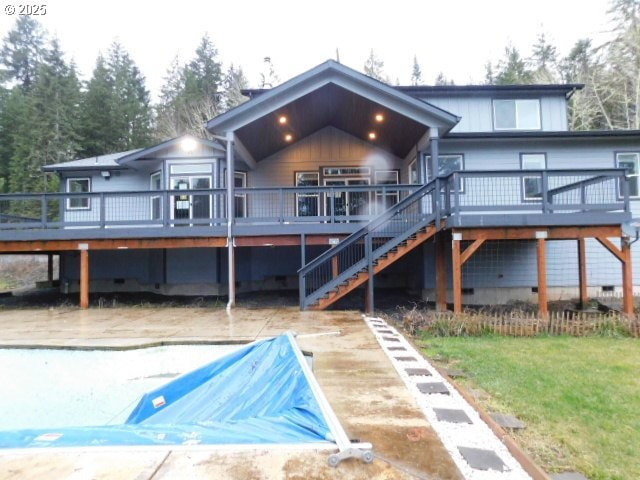 back of house featuring a wooden deck and a yard