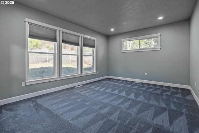 carpeted empty room featuring a textured ceiling