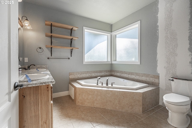 bathroom with tile patterned floors, vanity, toilet, and tiled tub