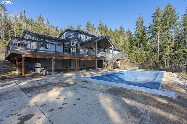 rear view of house featuring a wooden deck and cooling unit