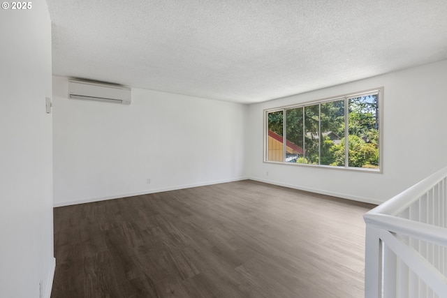 505/515 Empress Ave, Eugene, OR 97405 - spare room featuring a wall mounted AC, dark wood-type flooring, and a textured ceiling