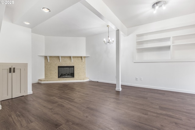 505/515 Empress Ave, Eugene, OR 97405 - unfurnished living room featuring a chandelier, dark wood finished floors, built in shelves, and a tile fireplace