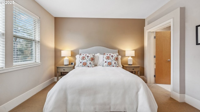 bedroom featuring baseboards and light carpet