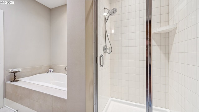 full bathroom with a shower stall and a bath