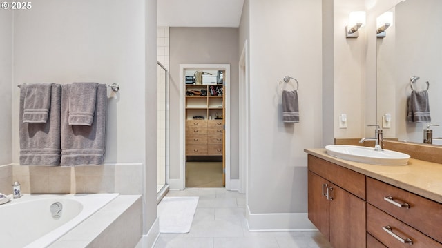 bathroom featuring tile patterned flooring, a garden tub, vanity, a spacious closet, and a stall shower