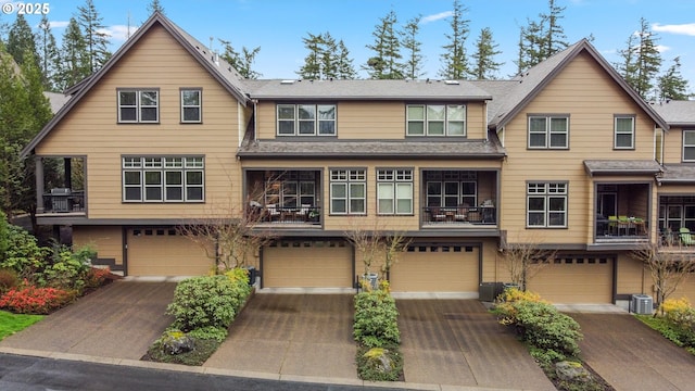 view of front of house featuring an attached garage, central AC, and driveway