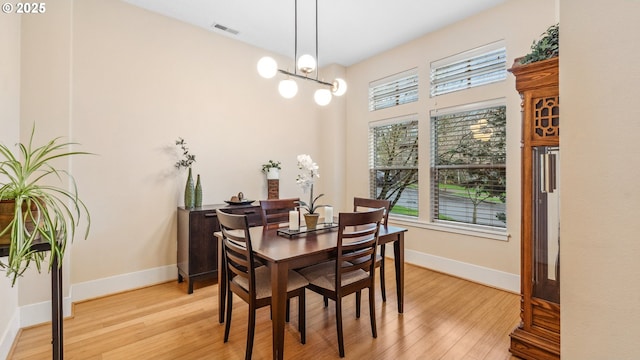 dining area featuring baseboards, visible vents, a wealth of natural light, and light wood finished floors