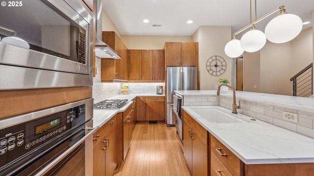 kitchen featuring brown cabinets, stainless steel appliances, and a sink