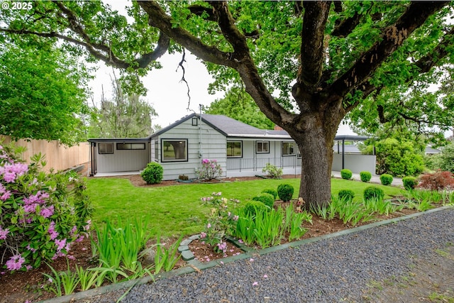 ranch-style home featuring a front yard and fence