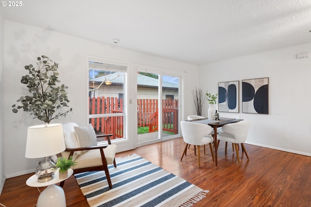 dining room with wood finished floors, baseboards, and a textured ceiling