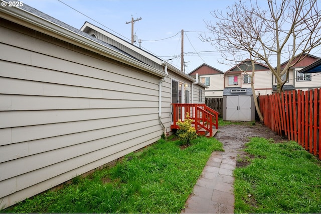 view of yard with a storage unit, an outbuilding, and fence