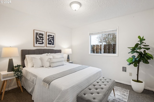 bedroom with baseboards, a textured ceiling, and carpet