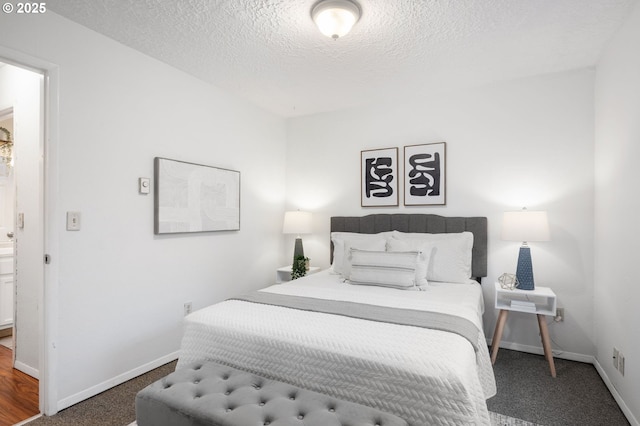 bedroom featuring carpet, baseboards, and a textured ceiling