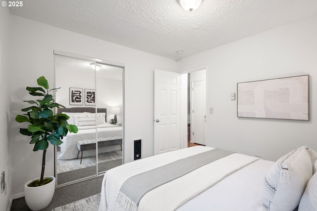 bedroom with carpet, a closet, and a textured ceiling