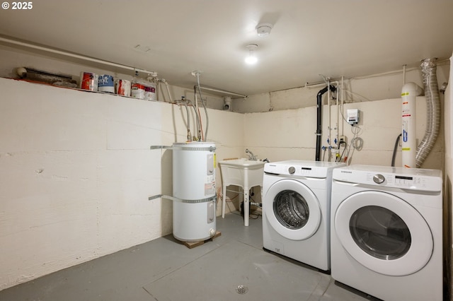 laundry area featuring washer and clothes dryer, a sink, concrete block wall, secured water heater, and laundry area